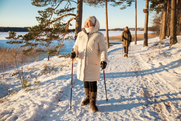 3 Winter Safety Tips for Seniors in Independent Living seniors in independent living take a snowy winter walk with walking aids for extra safety