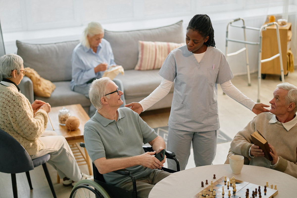 Healthcare worker checking in on sitting seniors